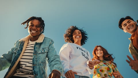 Group of happy young friends having fun outdoors, enjoying sunny day under blue sky. Joyful Gen Z people embracing friendship and laughter.; Shutterstock ID 2480341185