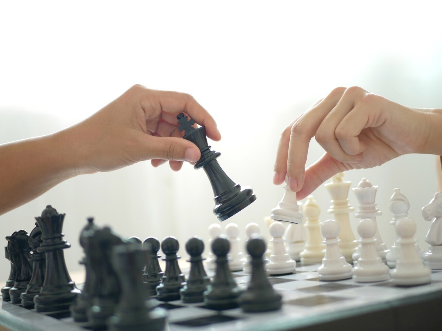 Two business women play chess and move chess pieces. Business management competition and leadership concepts.; Shutterstock ID 2473285247